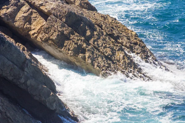 Meereswellen krachen mit weißem Schaum auf die Felsen — Stockfoto
