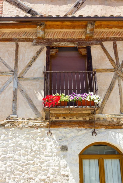 Balkonové okno s černou mřížku a květiny — Stock fotografie