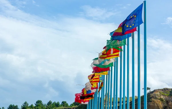 Banderas regionales de España en el viento sobre largos polos azules Fotos de stock libres de derechos