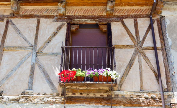 Balcony window with black grille and flowers — Stock Photo, Image