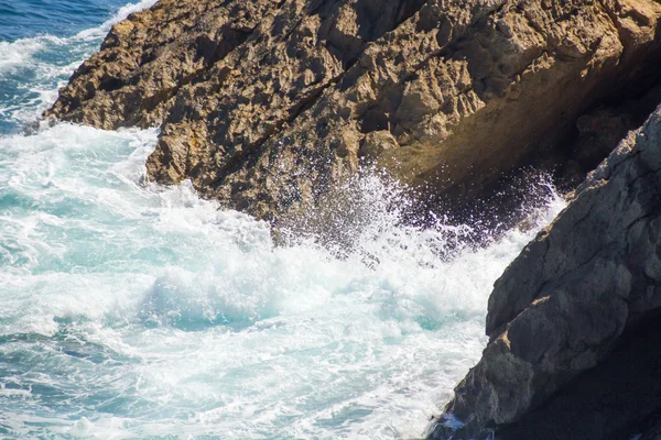 Olas del océano estrellándose en las rocas con espuma blanca — Foto de Stock