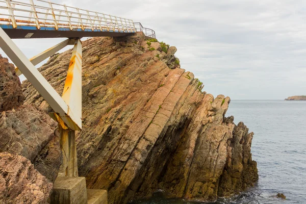 Eiserne Brücke mit Holzböden und Rost am Meer, in aviles, s — Stockfoto