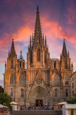 Famous Gothic Cathedral of the Holy Cross and Saint Eulalia or Barcelona Cathedral, seat of the Archbishop of Barcelona, Spain with tourists at sunset clipart