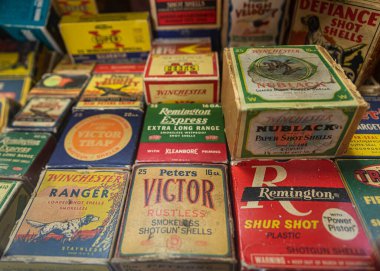 Vintage shotgun shells cartridge boxes by Remington, Winchester and other ammunition manufacturers at a gun shop clipart