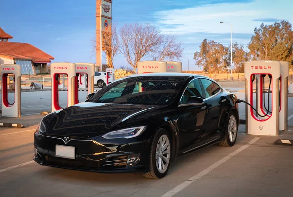 Siyah elektrikli Tesla Model S performans arabası süperşarjda.