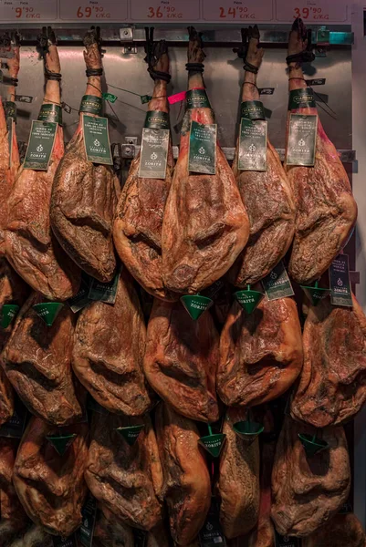 Celé kýty španělské šunky serrano iberico visící u řezníka v Pamploně ve Španělsku — Stock fotografie