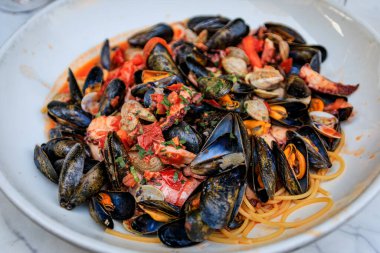 Frutti di mare deniz ürünleri makarnasıyla midye, karides, istiridye ve ahtapot Fransa 'nın güneyindeki Nice kasabasında bir restoranda servis ediliyor.