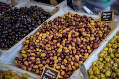 Fransa 'nın güneyindeki Nice Eski Kasabası' ndaki Cours Saleya provencal çiftçi pazarında taze siyah ve yeşil zeytin sergileniyor.
