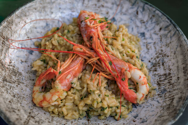 Тарелка ризотто с супом из лобстера с головой на креветках в итальянском ресторане в Старом городе Ниццы, на юге Франции