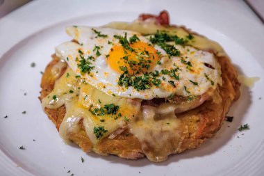 Çıtır Bernese usulü Rosti, üzerinde jambon, Gruyere peyniri ve yumurta bulunan doğranmış patates püresi Zürih, İsviçre 'de bir bayram yemeği için servis edilir.