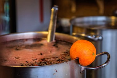 Sıcak şarapla kaynayan bir tencereden çıkan buhar, özel bir tezgahta baharat ve portakal dilimleri ile harmanlanmış, Fransa 'nın Strazburg Noel Pazarı,
