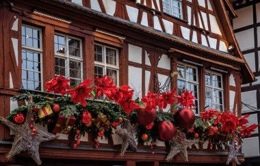 Fransa 'nın Strazburg kentindeki Noel Pazarı' nda şenlik dekorasyonları, melek süslemeleri ve arka planda tarihi yarım ahşap evler.