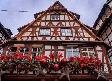 Fransa 'nın Strazburg kentindeki Noel Pazarı' nda şenlik dekorasyonları, melek süslemeleri ve arka planda tarihi yarım ahşap evler.