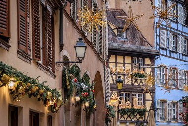 Fransa 'nın Strazburg kentindeki Noel Pazarı' nda şenlik dekorasyonları, melek süslemeleri ve arka planda tarihi yarım ahşap evler.