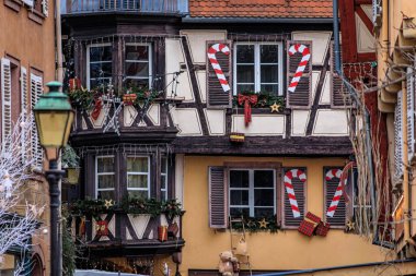 Fransa 'nın Alsace, Colmar kentindeki Küçük Venedik Kasabası' ndaki Noel Pazarı sırasında tarihi yarım ahşap evlerin şenlik süslemeleri ve süslemeleri.