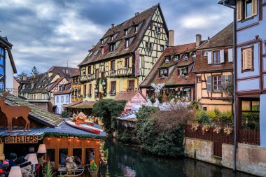 Colmar, Fransa - 15 Aralık 2024: Kutlama dekorasyonları, melek süslemeleri ve Noel Pazarı sırasında arka planda bulunan tarihi yarı keresteli evler