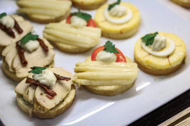 Belegte Brotli, İsviçre 'nin Zürih kentindeki bir fırında satılık beyaz servis tabağında tavuk, yumurta ve kuşkonmazlı açık yüzlü sandviçler.