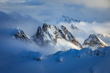 Grosser Spannort ve Kleiner Spannort tepeleri, İsviçre 'nin Engelberg kentindeki Titlis Dağı' ndan görülen kalın bulutların arasından karla kaplıdır.