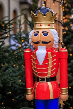 İsviçre 'deki Bern Noel Pazarı' nda sihirli bir tatil sahnesi, parıldayan ışıklar ve büyük bir fındıkkıran heykeli, bulanık