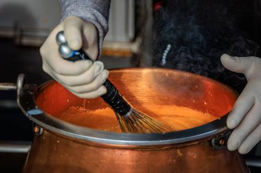 Buharlı karamel, İsviçre 'nin Bern kentindeki bir Noel pazarında badem kaplamak için büyük bir bakır tencereyi çırpıp sıcak bir tatil sahnesi oluşturdu.