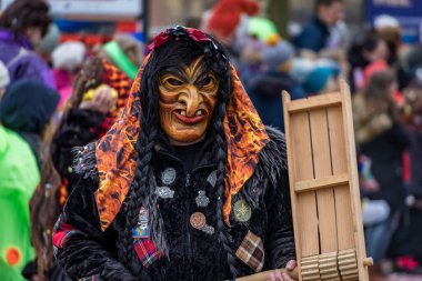 Zug, İsviçre - 1 Mart 2025: Cadı kıyafeti ve Larve maskeleri giymiş katılımcılar Fasnacht kış karnavalını bir şenlik geçit töreninde kutladılar