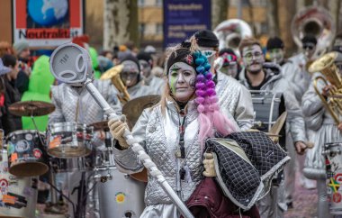Zug, İsviçre - 1 Mart 2025: Guggenmusik renkli kostümler içinde bando yürüyüşü ve Fasnacht kış karnaval geçit töreninde yüz boyama gösterileri