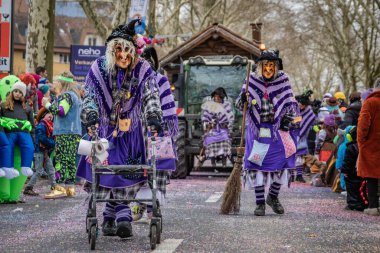Zug, İsviçre - 1 Mart 2025: Cadı kıyafeti ve Larve maskeleri giymiş katılımcılar Fasnacht kış karnavalını bir şenlik geçit töreninde kutladılar