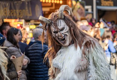 Bern İsviçre - 8 Mart 2025 'te İsviçre' deki Fasnacht karnavalında boynuzlu ahşap maskeli, Tschaggatta giysili bir adam