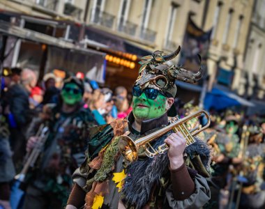 Bern, İsviçre - 1 Mart 2025: Guggenmusik renkli kostümler içinde bando yürüyüşü ve Fasnacht kış karnavalı geçit töreninde yüz boyama gösterileri