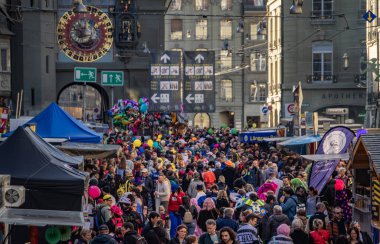 Bern, İsviçre - 8 Mart 2025: Zytglogge kulesi yakınlarındaki tarihi Kramgasse 'de kutlama kalabalığı geçit töreni sırasında Fasnacht karnavalı kutlandı