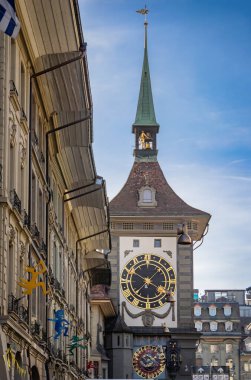 Fasnacht kış karnavalı sırasında ortaçağ cephesinden, arka planda İsviçre 'nin Bern kentindeki Zytglogge saat kulesinden şenlik dekorasyonları asılıyor.