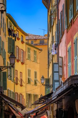 Orta Çağ Eski Kasabası 'nda ya da Fransa' nın Nice şehrinde Fransız Rivierası 'nda Vieille Ville' de renkli geleneksel evleri olan çarpık, eğri büğrü bir sokak.