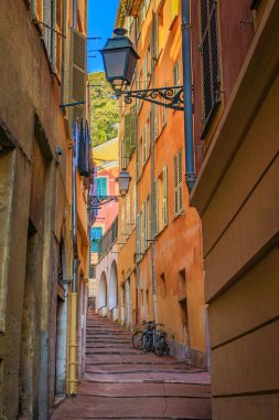Orta Çağ Eski Kasabası 'nda ya da Fransa' nın Nice şehrinde Fransız Rivierası 'nda Vieille Ville' de renkli geleneksel evleri olan çarpık, eğri büğrü bir sokak.
