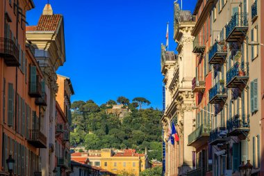 Sokaklarda çiçek saksıları olan geleneksel Akdeniz evlerinin cepheleri Eski Fransa, Nice Kasabası
