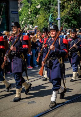 Zürih, İsviçre - 28 Nisan 2025: Sechselauten geçit töreninde geleneksel tarihi kostümlü lonca üyeleri, baharın gelişini kutluyorlar