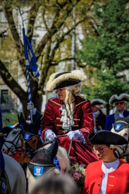 Zürih, İsviçre - 28 Nisan 2025: Sechselauten geçit töreninde geleneksel tarihi kostümlü lonca üyeleri, baharın gelişini kutluyorlar
