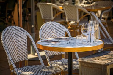 Fransa 'nın güneyindeki Cagnes sur Mer kasabasının Haut de Cagnes tepesindeki açık hava restoranında müşterileri bekleyen Al fresco masaları.