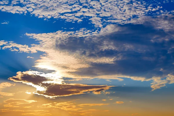 Sunset sky with golden and blue clouds — Stock Photo, Image