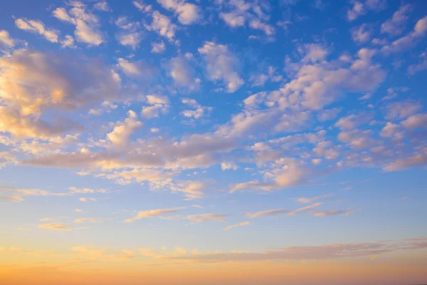 Ciel couchant avec des nuages dorés et bleus — Photo