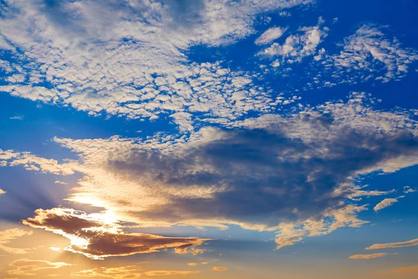 Закат неба с золотыми и голубыми облаками — стоковое фото