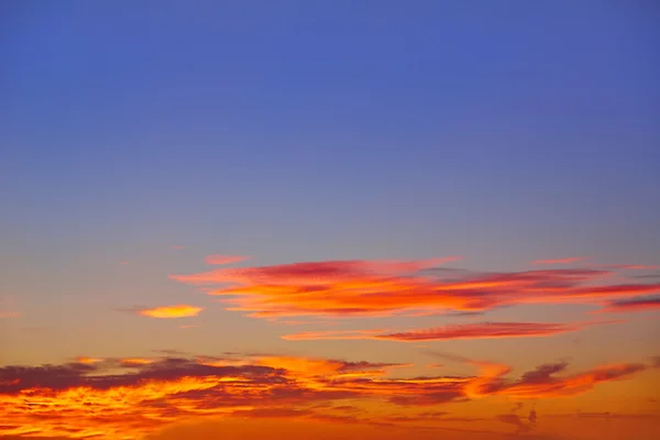 Sunset sky with golden and blue clouds — Stock Photo, Image