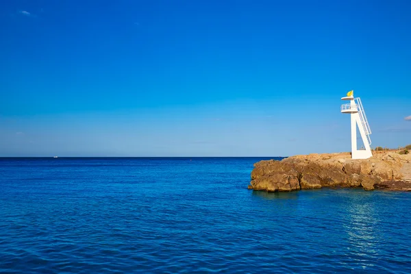 Пляж и башня Denia Las Rotas Trampoli в Испании — стоковое фото
