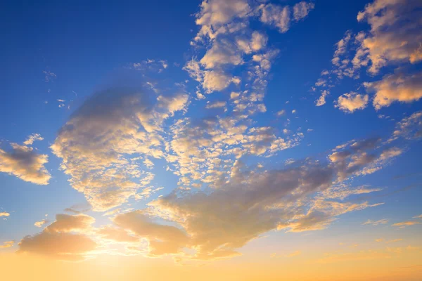 Небо заходу сонця з золотими та блакитними хмарами — стокове фото