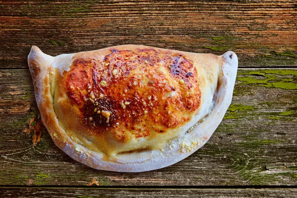 Пицца Кальцоне сложена как котлета на деревянной — стоковое фото