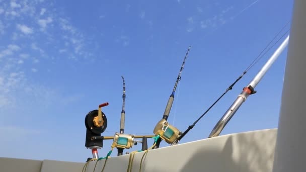 Pesca en barco curricán en mar azul con cañas y carretes — Vídeo de stock