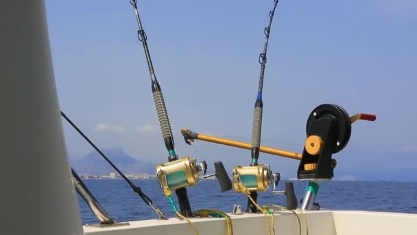 Pesca en barco curricán en mar azul con cañas y carretes — Vídeo de stock