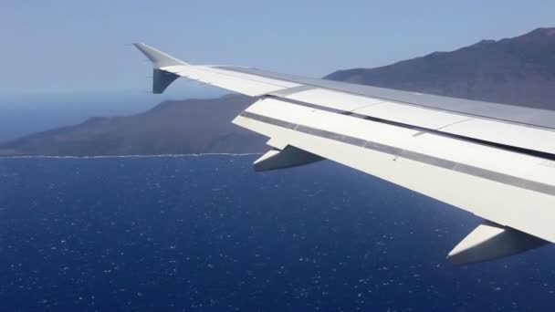Křídlo letadla letící nad mraky v modré obloze pohledu Fuerteventura — Stock video