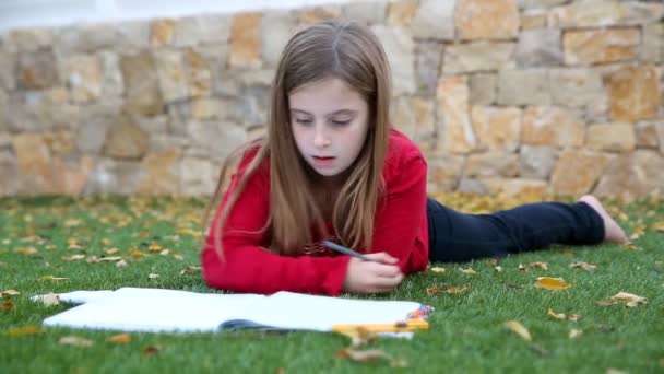 Blond liten flicka matematik läxor om på gräs — Stockvideo