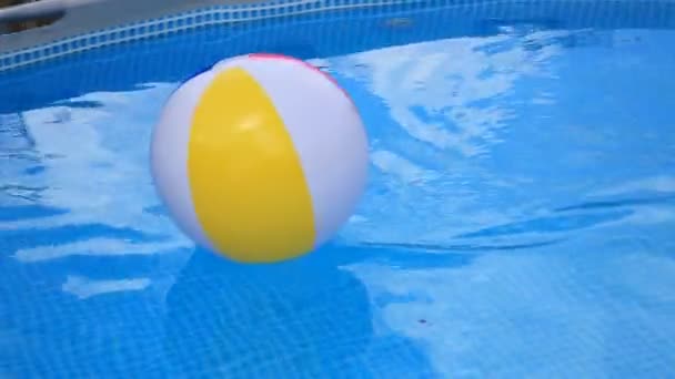 Beachball schwimmt im Schwimmbad in Bewegung — Stockvideo