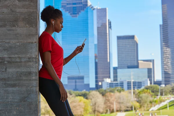 Runner menina ouvindo fones de ouvido de música na cidade — Fotografia de Stock